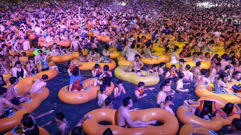 large number of people in a pool at a water park