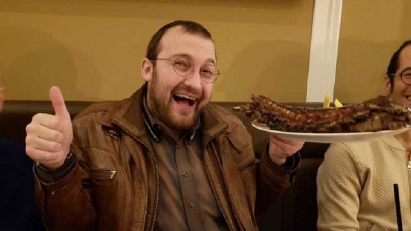 iohk founder and cardano ada creator charles hoskinson giving thumbs up and holding a plate of ribs